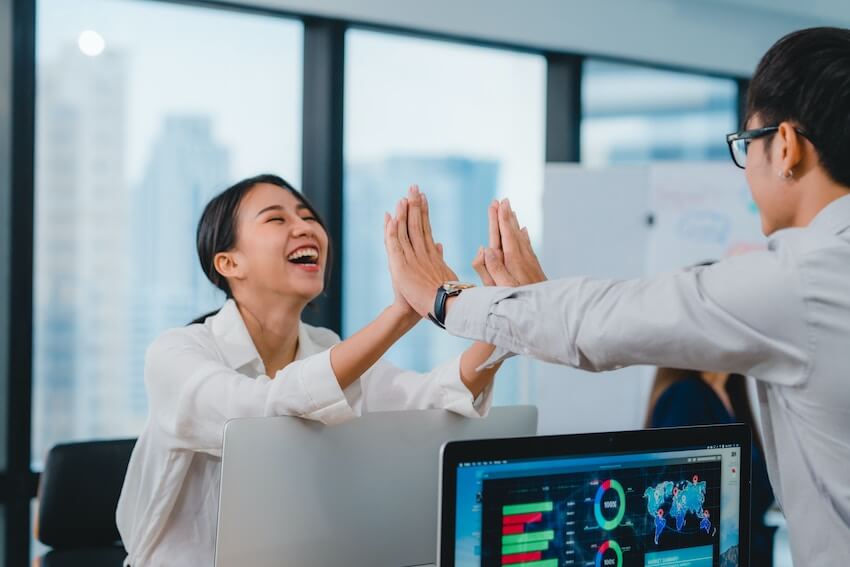 friends celebrating a work victory with high fives