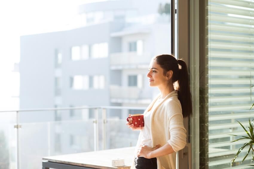 content young woman standing in front of a doorway