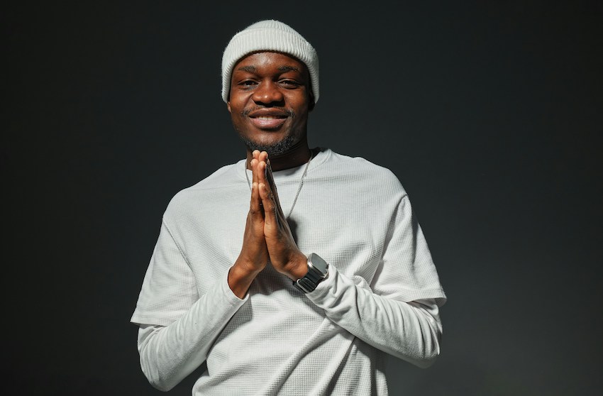 smiling man with his hands together in a sign of gratitude