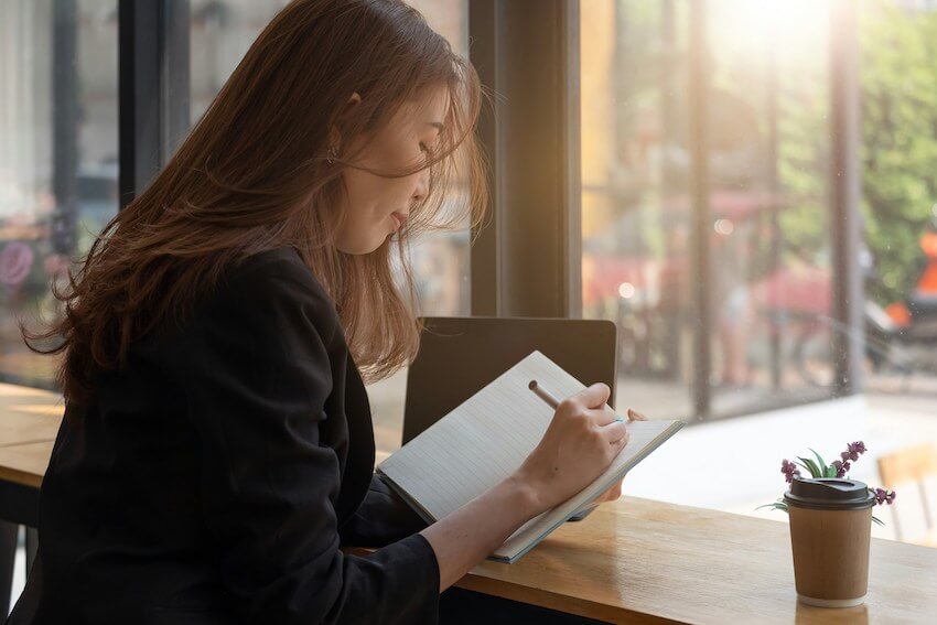 woman writing in her gratitude journal