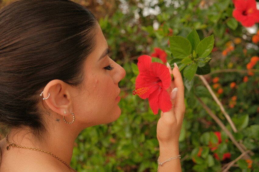 woman smelling a hibiscus flower