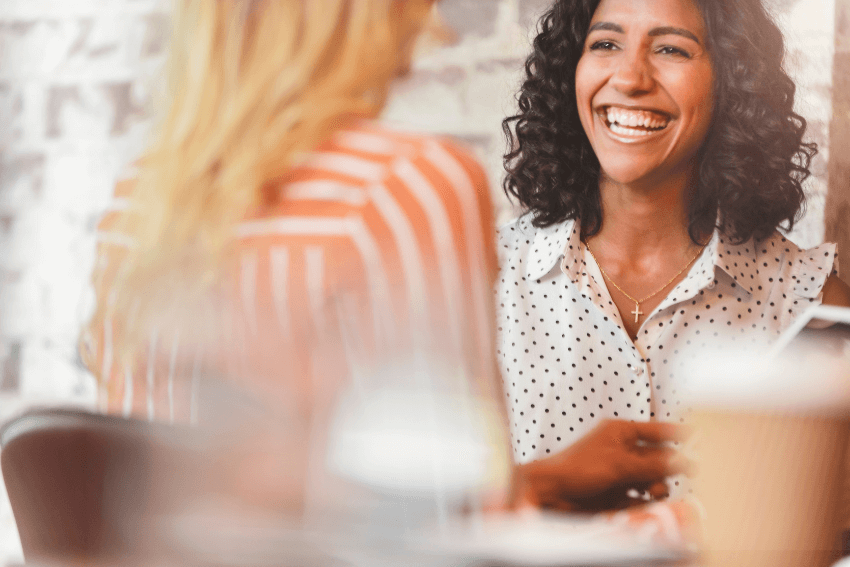two smiling women having a happy conversation