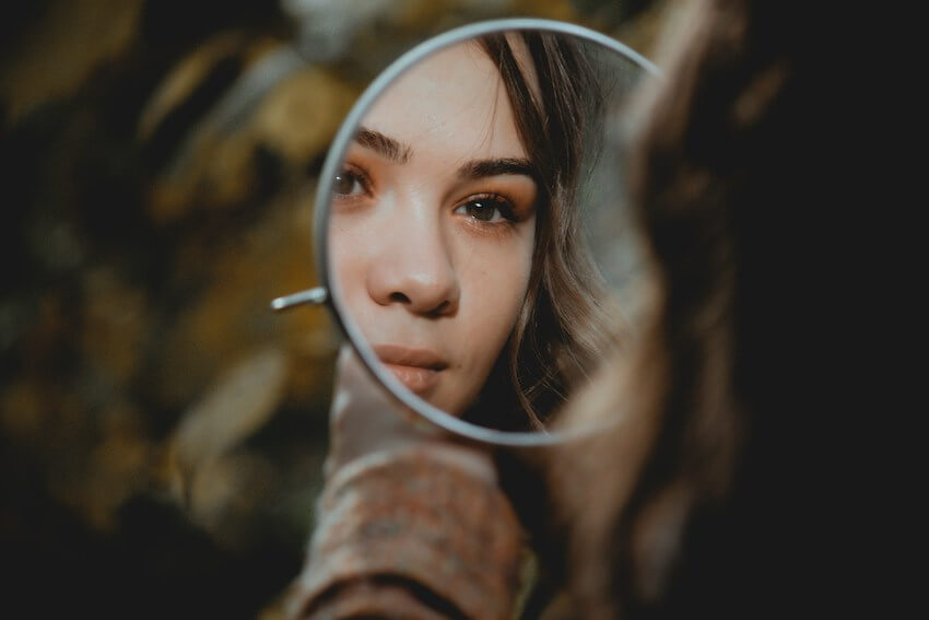 woman looking at herself in the mirror