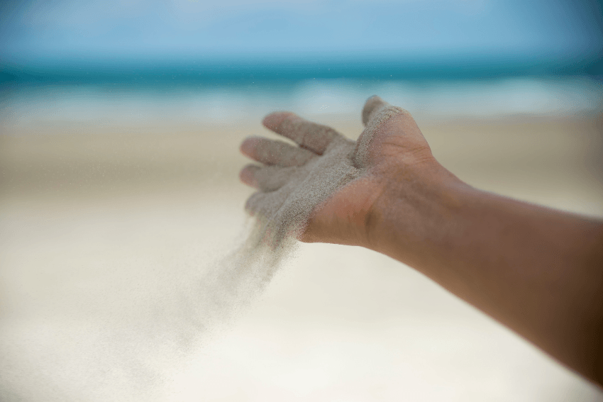 hand with sand slipping through the fingers
