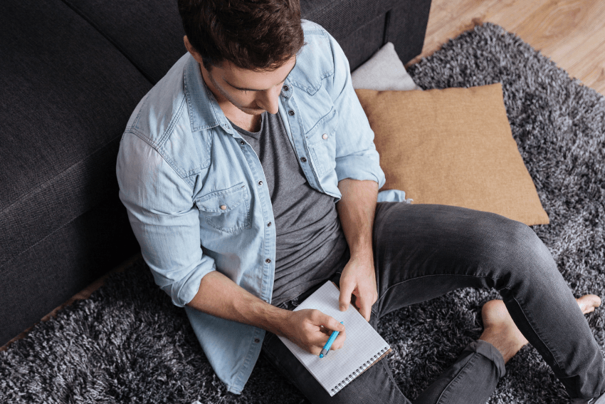 man sitting on the floor, journaling