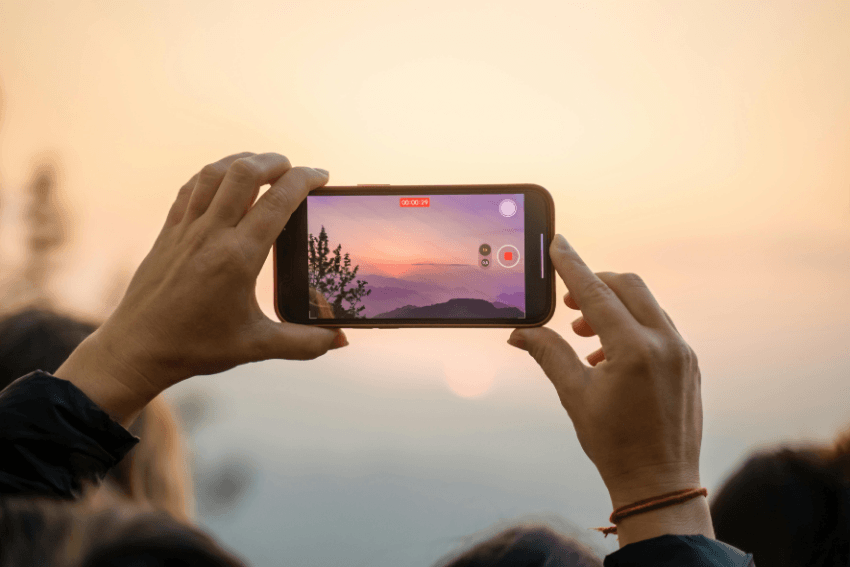 person filming a sunrise