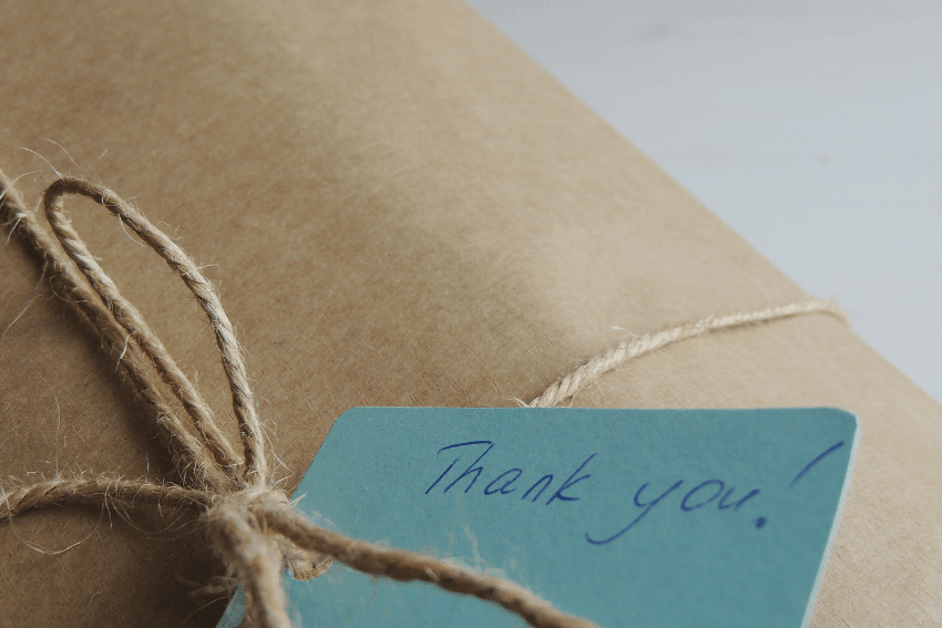 Kraft paper gift wrapped in twine with a handwritten "Thank you!" tag, a small act of appreciation at the heart of the Cherish List™ gratitude practice