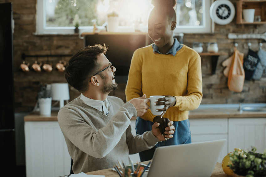 smiling man receiving a cup of coffee from the barista