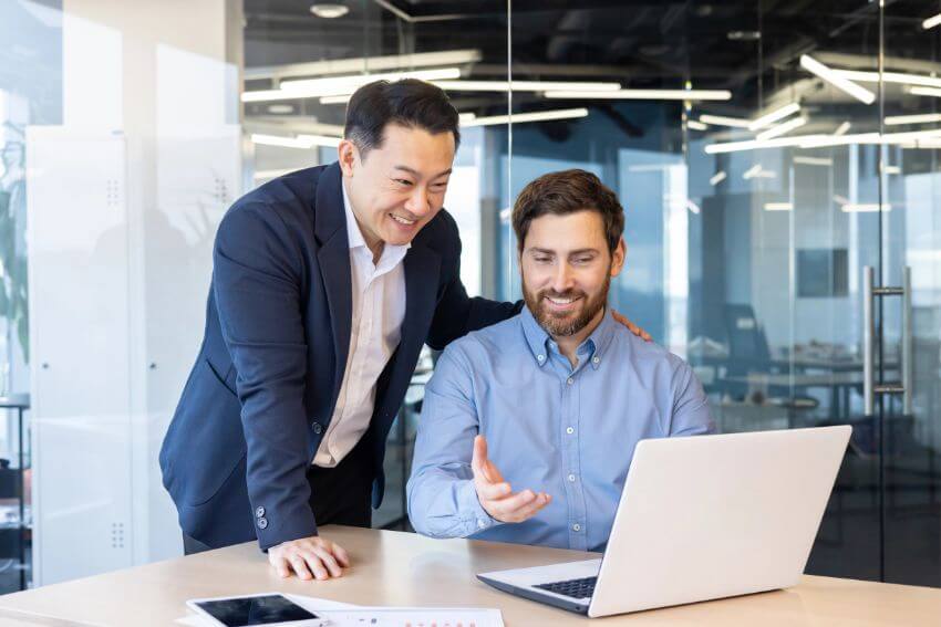 A senior manager leaning in with a hand on a colleague's shoulder, showing the kind of empathy examples that make people feel seen at work.