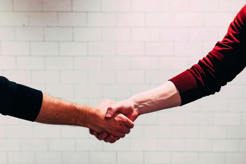 Two people shaking hands, a timeless gesture of mutual respect between equals.